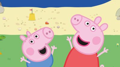 Illustratie van twee vrolijke roze tekenfilmvarkentjes die naast elkaar staan en hun armen omhoog houden. Op de achtergrond is een strand te zien met zand, schelpen en een omgekeerde emmer met een vlaggetje, en daarachter de zee. De figuren lachen en kijken blij omhoog.