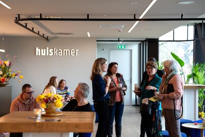 Medewerker in gesprek met vrienden in de huiskamer