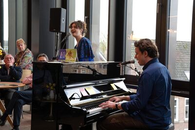 Vrienden luisteren naar zang en piano