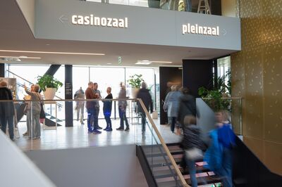 Sfeerfoto waarbij mensen de trap naar de eerste verdieping op en af lopen 