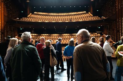 Vrienden staan op het toneel van de grote zaal 