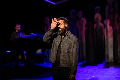 Saman Amini met zijn hand voor zijn hoofd in het decor