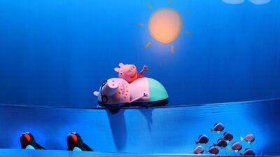 Peppa Pig en haar vriendjes zwemmen vrolijk op een grote rubberen luchtmatras onder een zon.