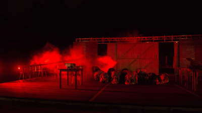 scenefoto van gevangenen in rook en rode gloed