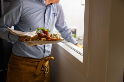 Een horeca-collega van Theater aan de Parade serveert dinergerechten uit