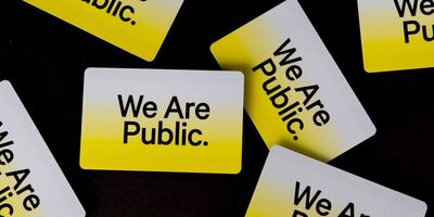 Zwarte ondergrond met meerdere gele kaarten met de tekst "We Are Public." in het midden.
